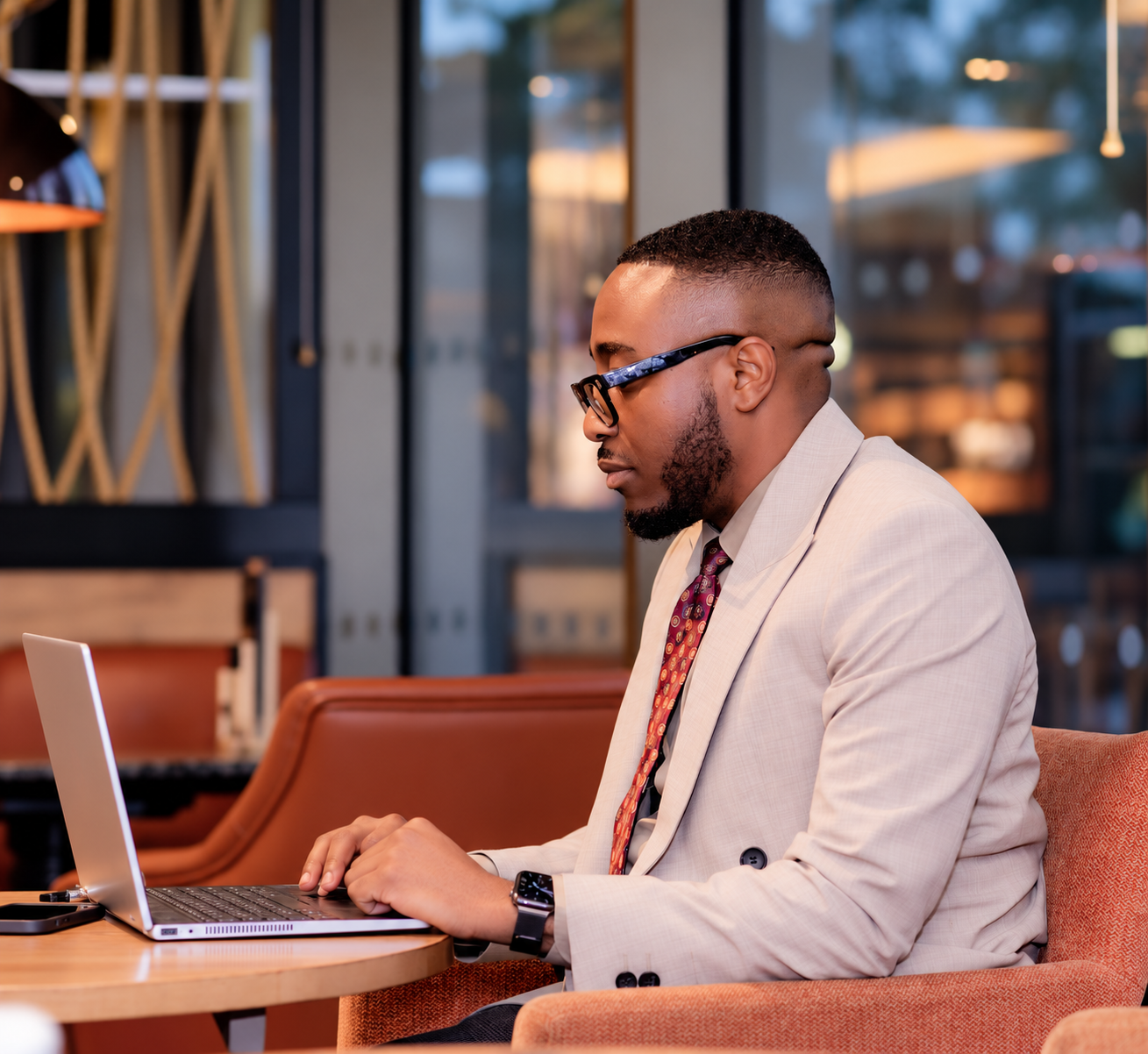 Dr Daniel Moses seated at a table working on his laptop